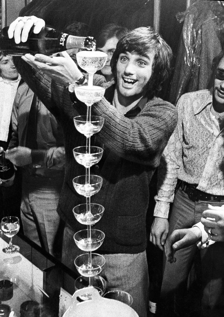 Detail of George Best, footballer pouring champagne by Associated Newspapers