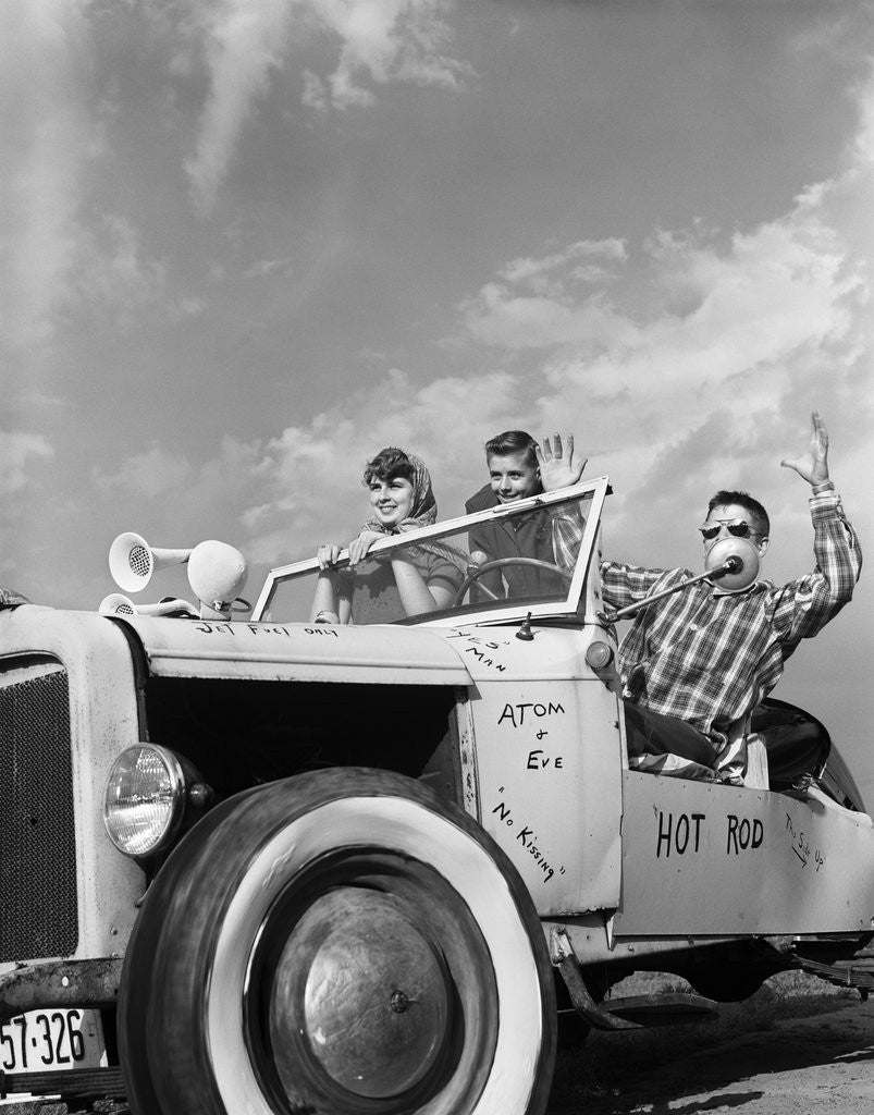 Detail of 1950s teens in roofless hotrod with graffiti atom & eve no kissing etc. by Corbis