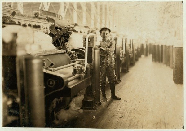 Detail of Boy sweeper by carding machines at Lincoln Cotton Mills, Evansville, Indiana in stockinged feet on a slippery floor, 1908 by Lewis Wickes Hine