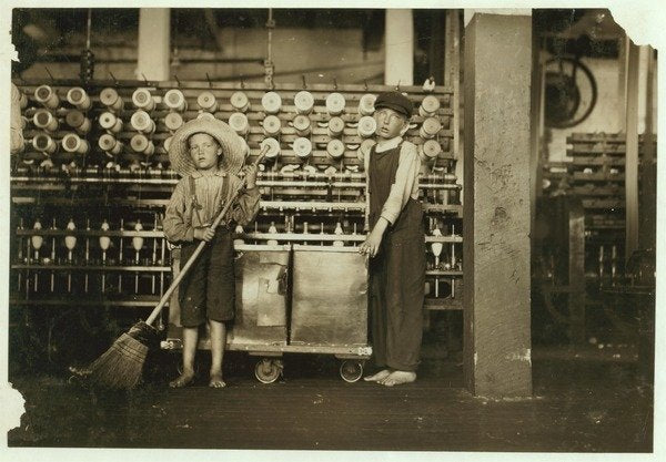 Detail of 12 year old doffer Ronald Webb and 7 year old Frank Robinson, son of cardroom boss, who sweeps and doffs at Roanoke Cotton Mills, Virginia, 1911 by Lewis Wickes Hine