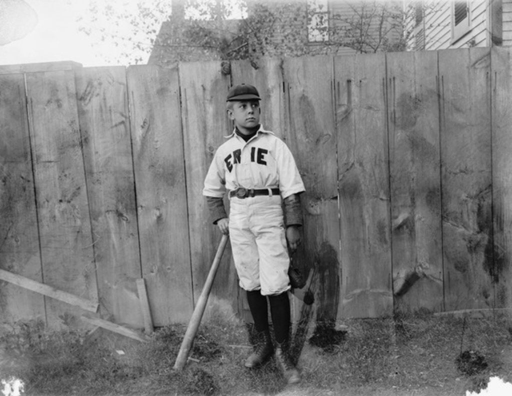 Detail of Boy in baseball uniform by fence by Anonymous