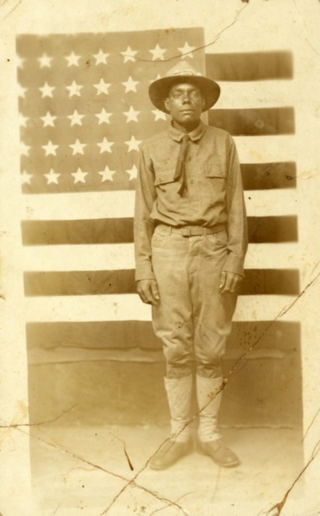 Detail of World War I soldier with American flag in background, 1914-18 by American Photographer