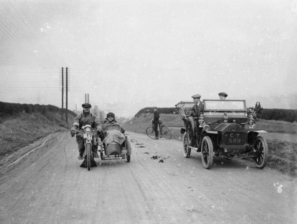 Detail of A motorcycle and sidecar passing a car and cyclist on the road by Unknown