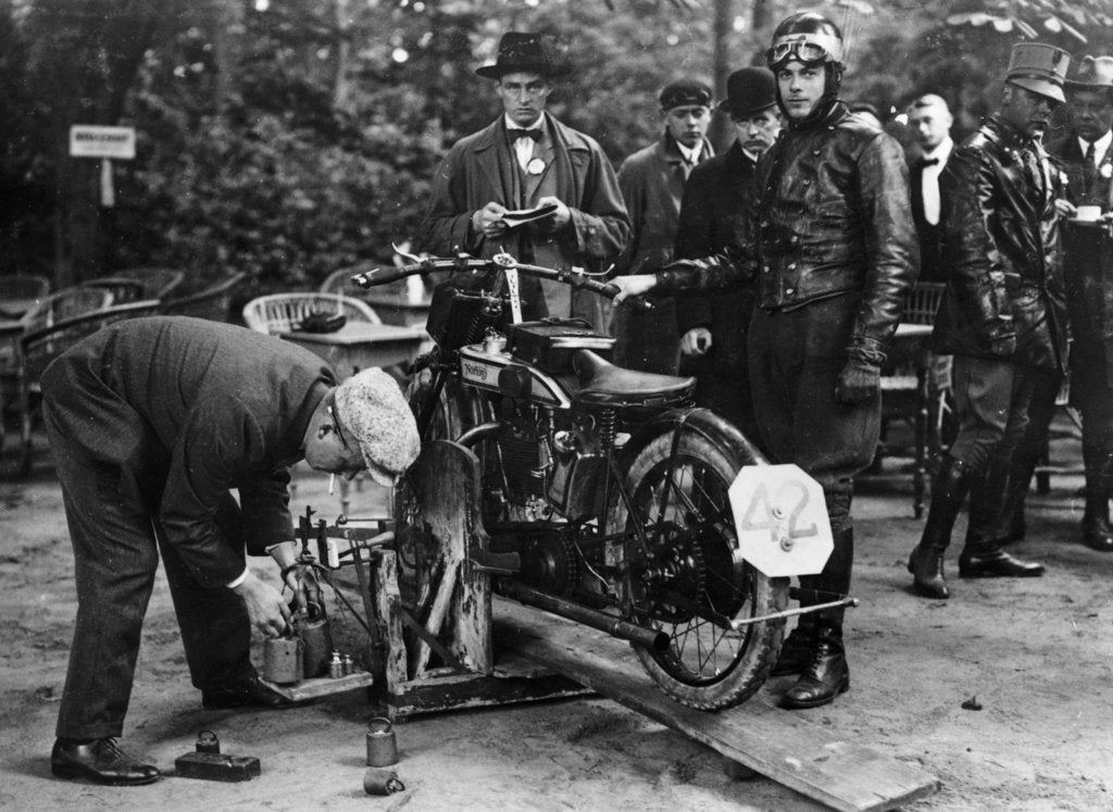 Detail of Karl Burlage having his Norton bike weighed for a TT competition by Unknown
