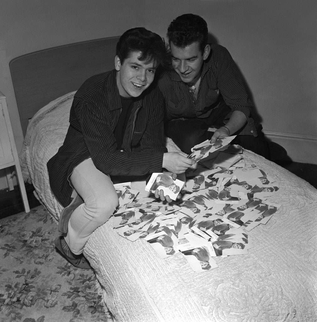 Detail of Cliff Richard looking some promotional photographs by Harry Hammond