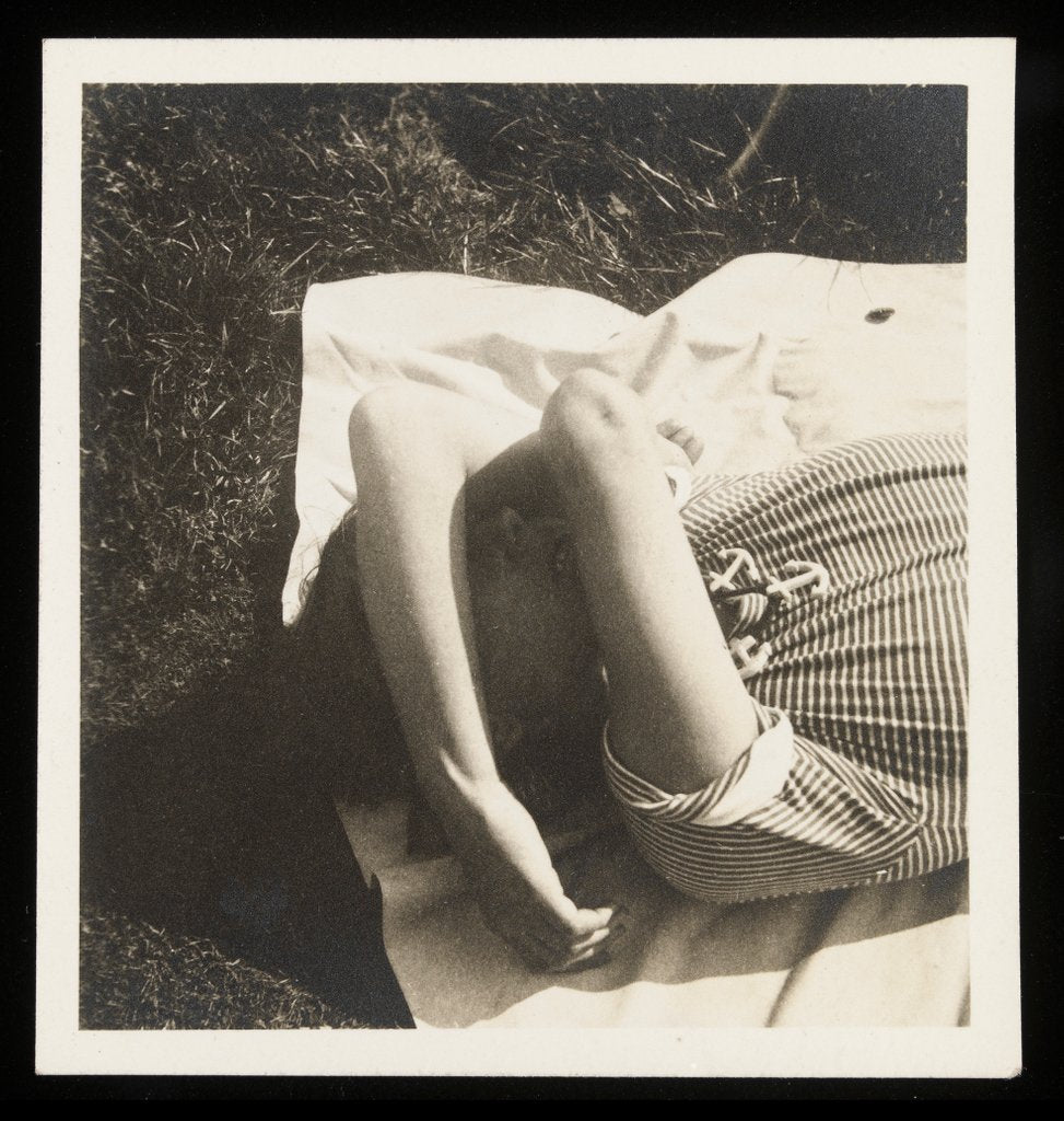 Detail of Woman wearing striped t-shirt lying on rug with both arms covering face by Curtis Moffat