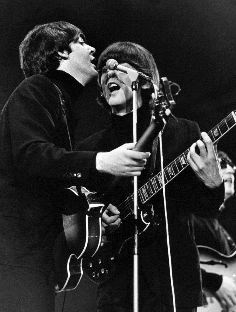 Detail of Paul McCartney and George Harrison on stage by Associated Newspapers