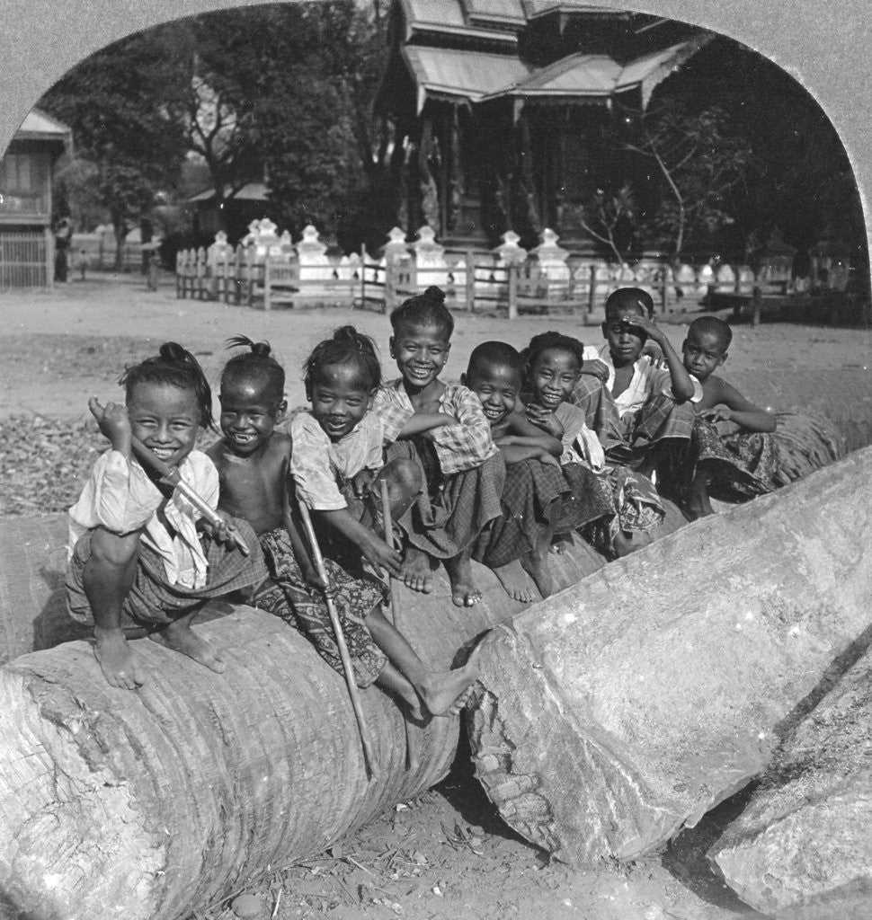 Detail of Burmese children sitting on a palm log, Burma by Stereo Travel Co