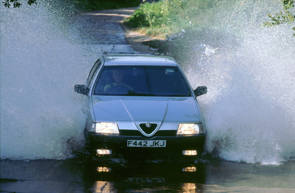 Detail of 1989 Alfa Romeo 164 driving through a ford by Unknown
