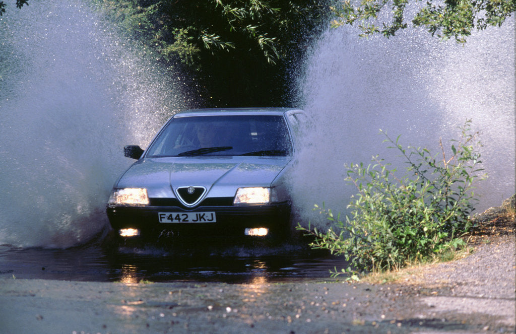 Detail of 1989 Alfa Romeo 164 driving through a ford by Unknown