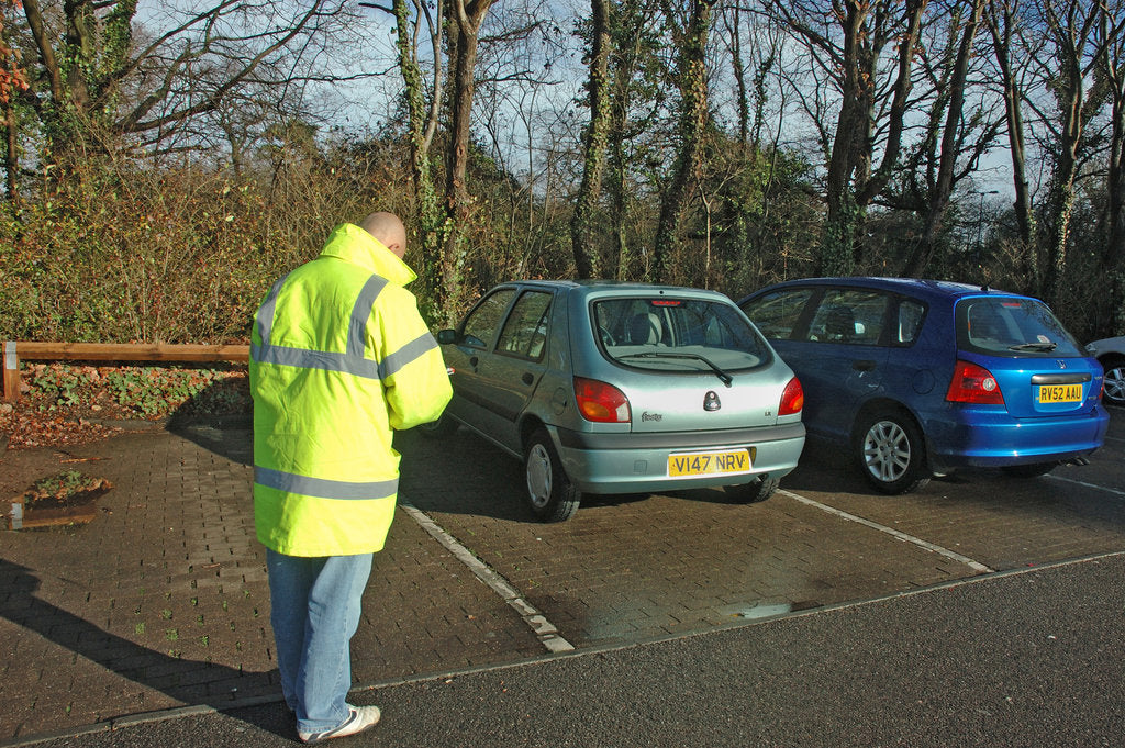 Detail of Car Park attendant recording car registration numbers by Unknown