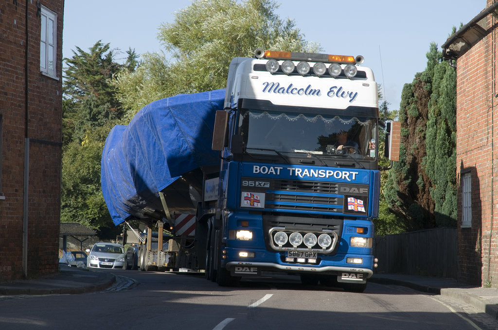 Detail of DAF 95 XF wide load truck carrying a life boat through a small village by Anonymous
