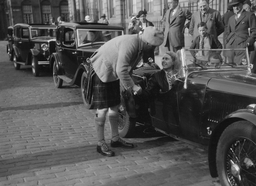 Detail of Kitty Brunell in her Aston Martin, chatting to a man in Highland dress, RSAC Scottish Rally, 1933 by Bill Brunell