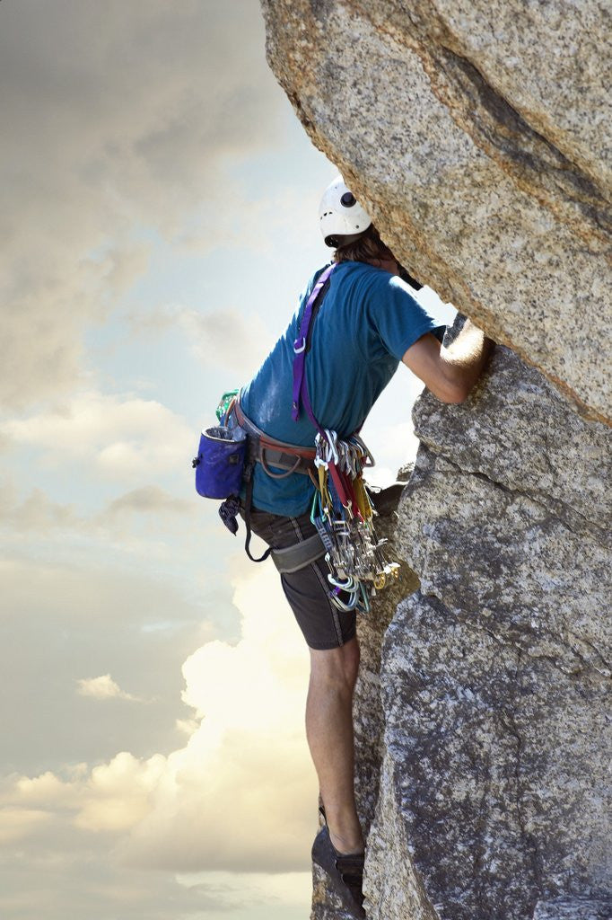 Detail of Young man rock climbing up a vertical cliff by Anonymous
