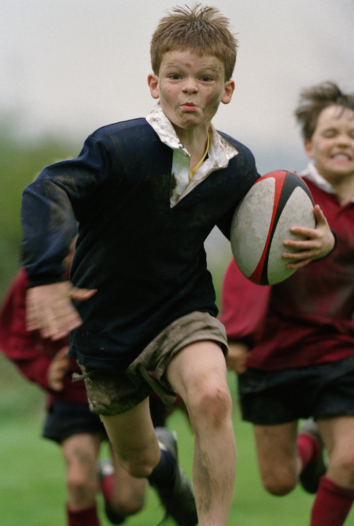 Detail of Boy Running with Rugby Ball by Corbis