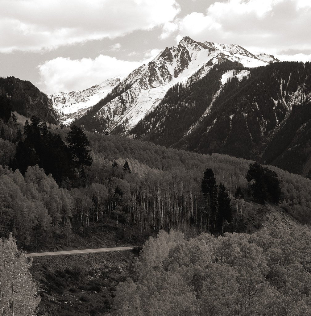 Detail of High angle view of road winding up the side of a hill with mountains in the distance by Anonymous