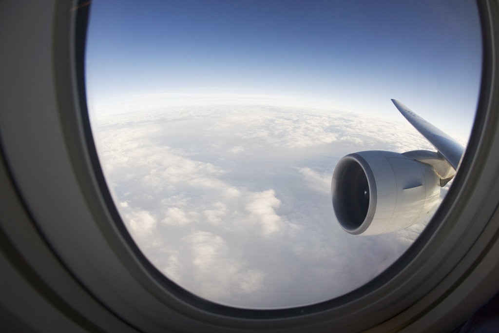 Detail of Airplane Window Looking Out on Cloudy Sky by Corbis