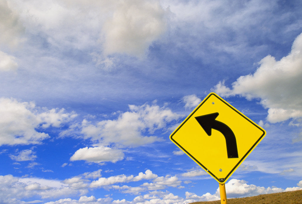 Detail of Curve Road Sign on Highway Against Sky by Corbis