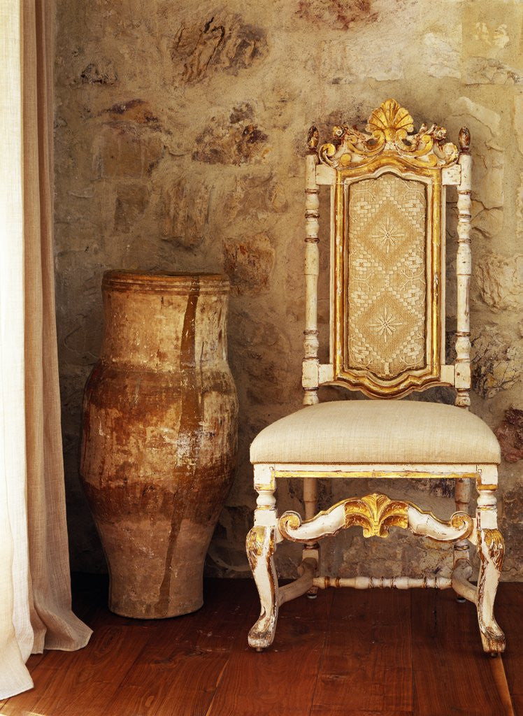 Detail of A pot is kept beside a chair against the wall in the house by Corbis