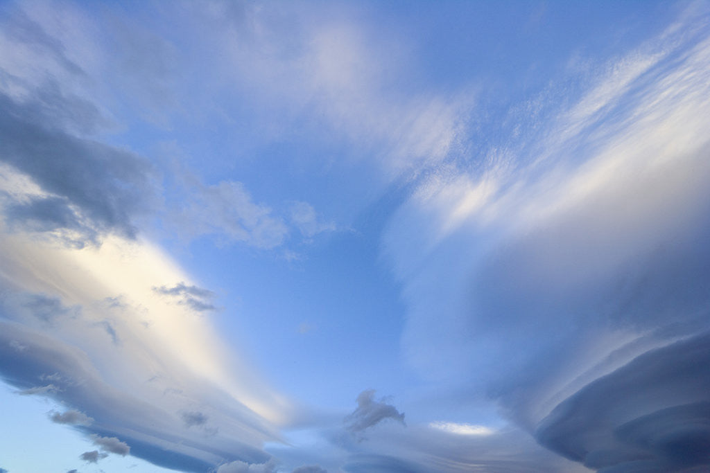 Detail of Bright Cumulus and Lenticular Clouds at Sunrise by Corbis