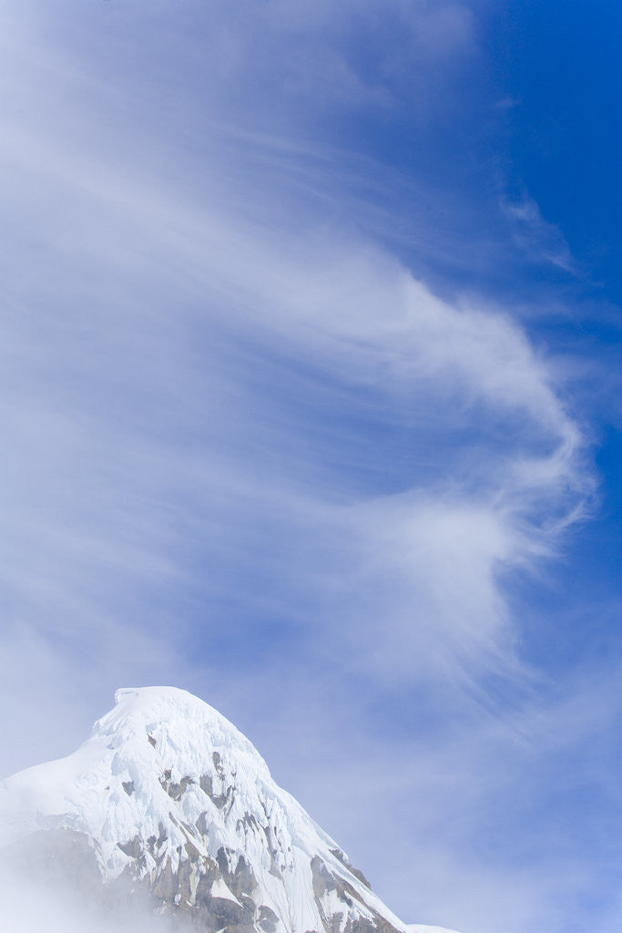 Cirrus Clouds Floating by Snow-capped Mountain Peak by Corbis