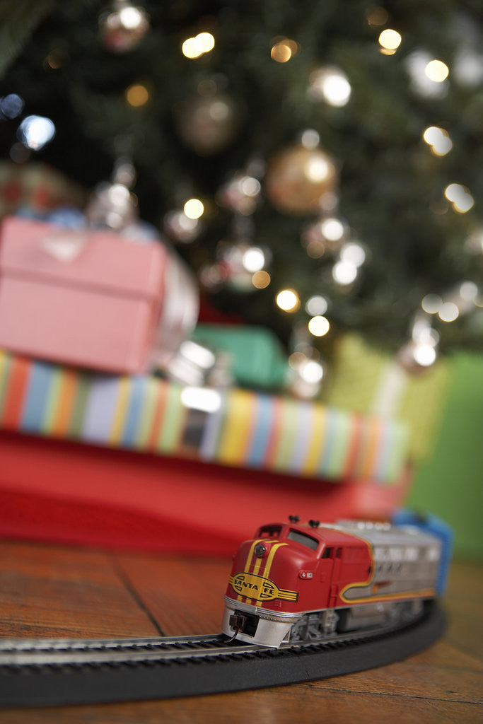 Detail of Toy train running beneath Christmas tree by Anonymous