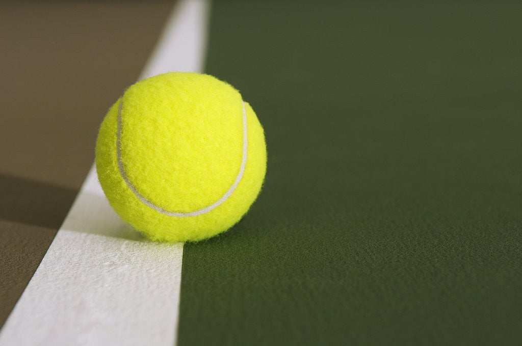 Detail of Tennis ball on white boundary stripe by Corbis