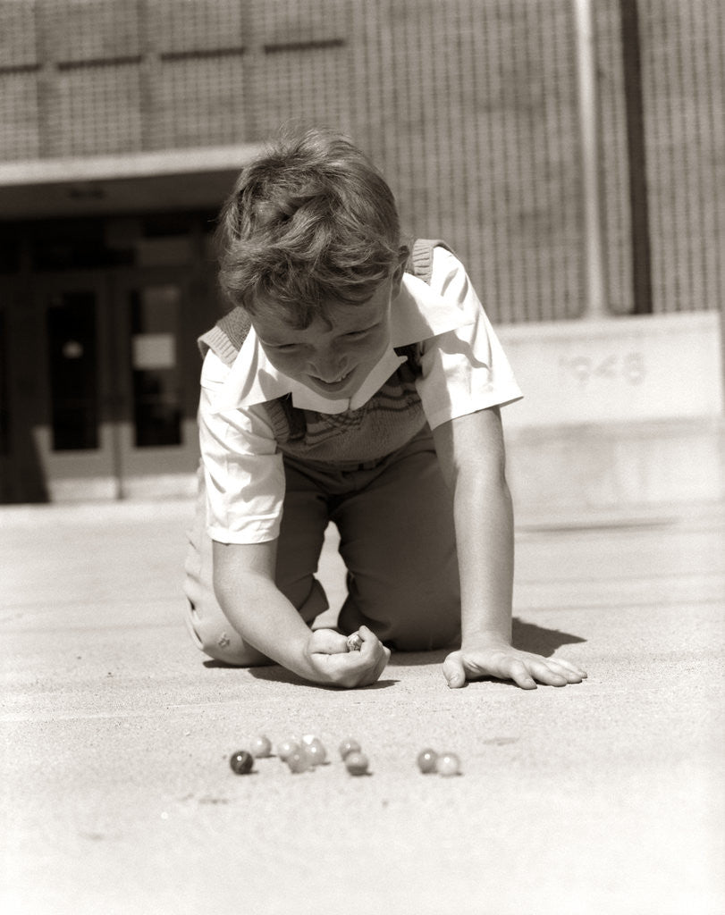 Detail of 1950s Boy Ready To Shoot Kneeling On School Yard Ground Playing Game Of Marbles by Anonymous