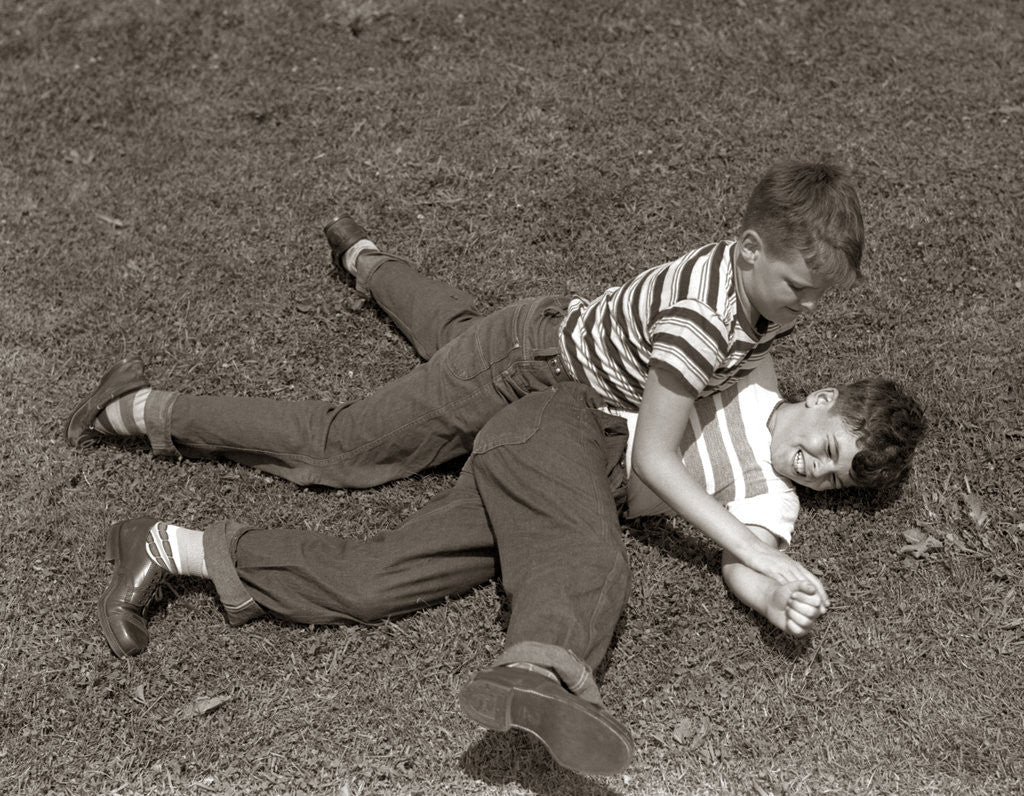 Detail of 1950s Two Boys Wear Tee Shirts Blue Jeans Playing Rough Fighting Wrestling On The Grass by Anonymous