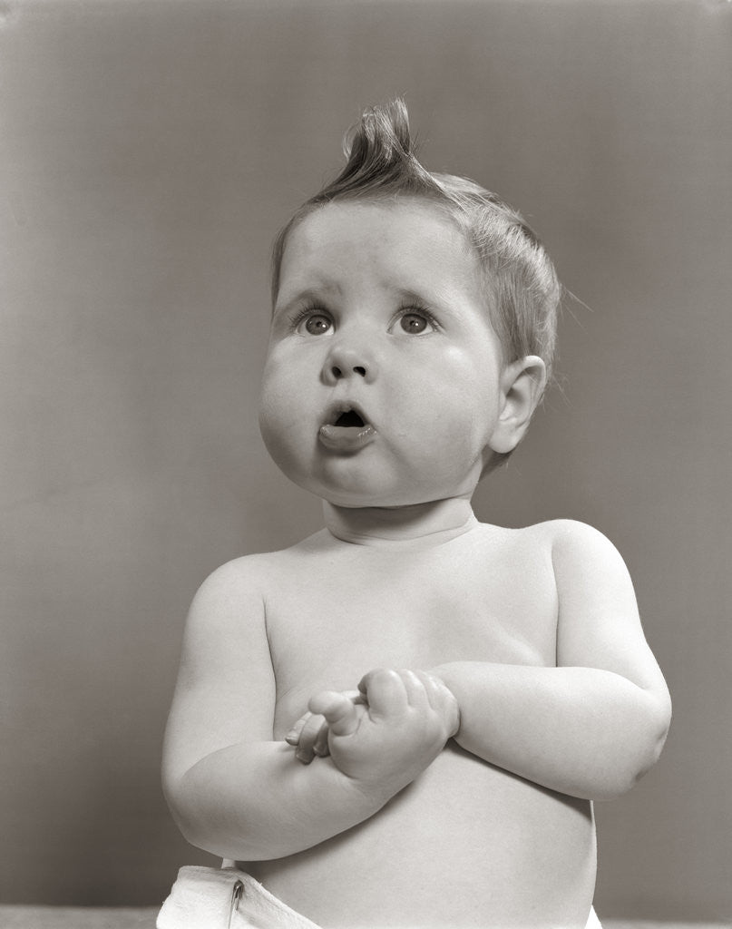 Detail of 1950s Worried Baby Looking Up Uncertain With Clasped Hands Studio by Anonymous