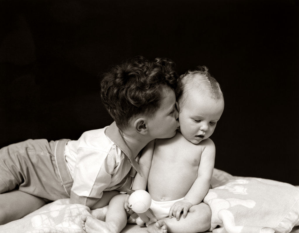 Detail of 1940s Curly Haired Boy Toddler Leaning And Kissing Cute Baby by Anonymous