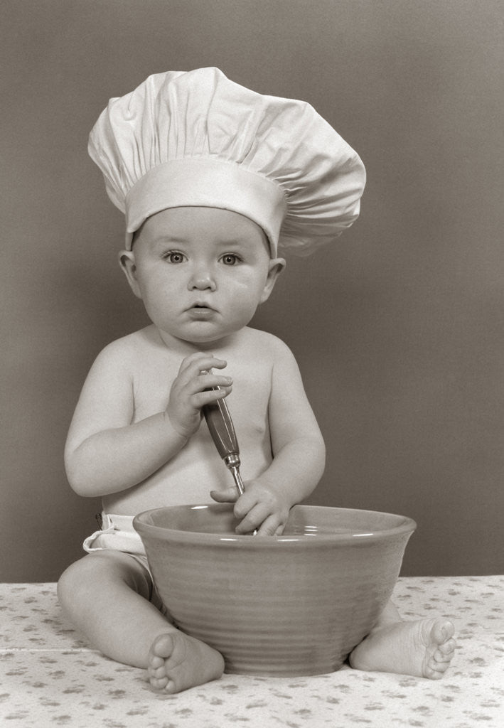 Detail of 1940s 1950s Baby Cook With Chef Hat Spoon Mixing Bowl Staring Straight Ahead Studio by Anonymous
