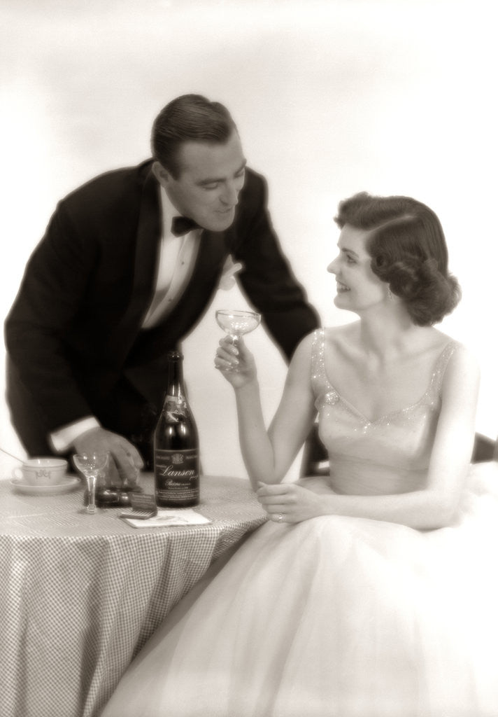 Detail of 1950s Formal Dress Couple Man In Tuxedo Woman Wearing Gown Holding Champagne Glass by Corbis