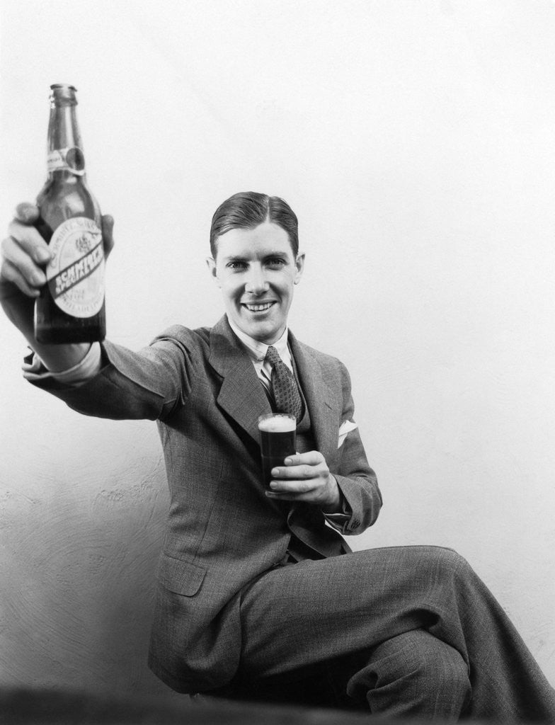 Detail of 1920s 1930s Man Holding Up Huge Distorted Beer Bottle In One Hand And A Regular Size Glass Of Beer In Other by Anonymous