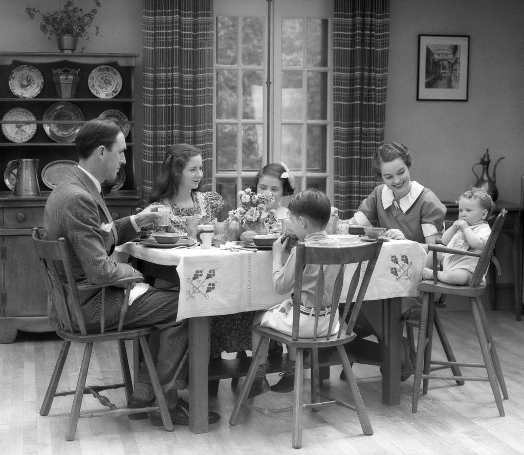Detail of 1930s Family Of 6 Sitting At The Table In A Dining Room Eating Breakfast The Baby Is Sitting In A High Chair by Anonymous
