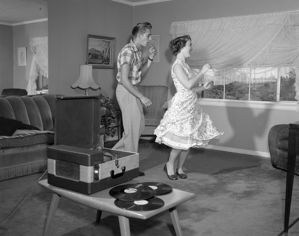 Detail of 1950s Laughing Teenage Couple Dancing To The Phonograph Playing 78 Rpm Records In Living Room by Anonymous