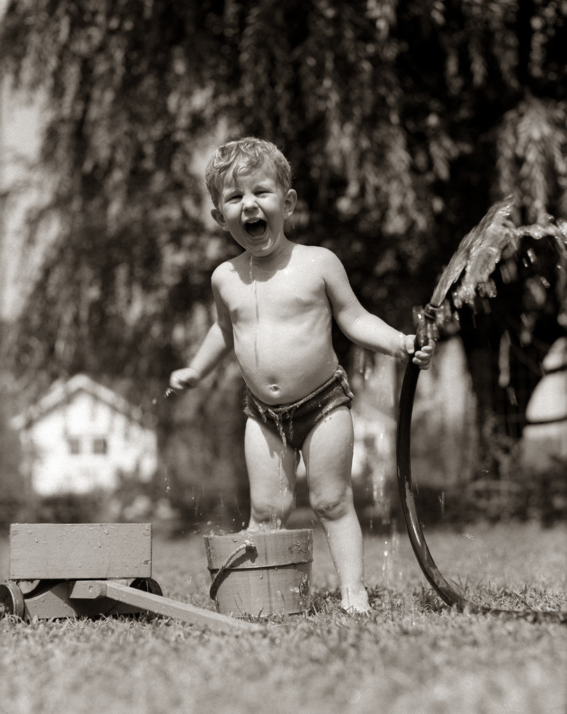 Detail of 1940s 1950s Wet Young Boy Toddler Outside Playing With Water Hose by Corbis