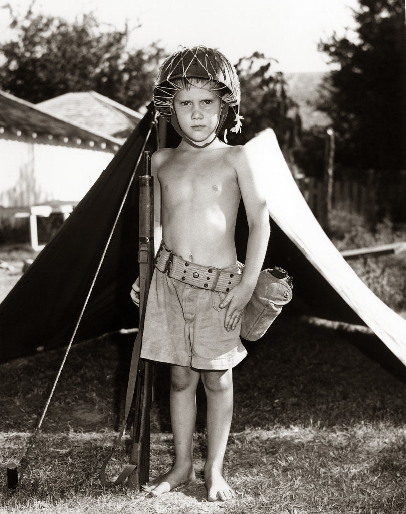 Detail of 1950s Boy Playing Soldier Standing With Rifle Helmet Canteen Tent by Anonymous