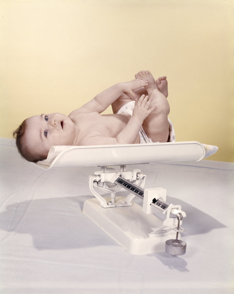 Detail of 1950s 1960s Baby Lying On Weight Scale by Corbis