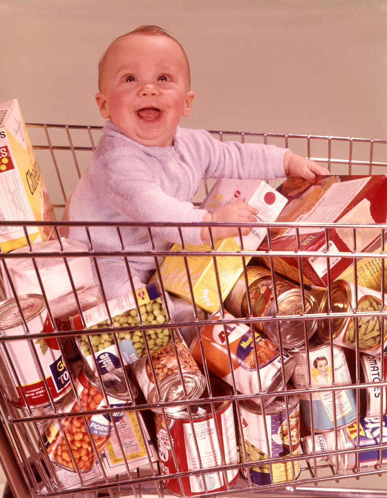 Detail of 1960s Happy Baby Sitting Inside Shopping Cart Full Of Groceries by Anonymous