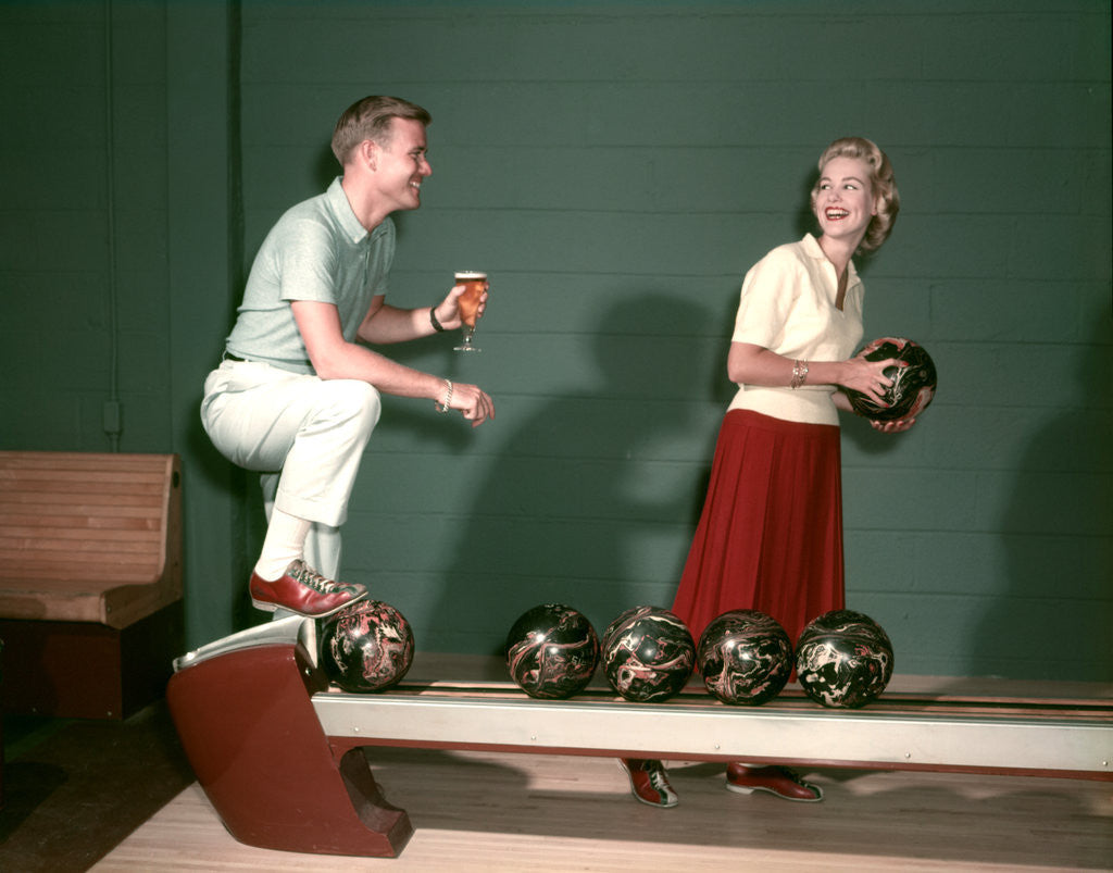 Detail of 1950s Couple In Bowling Alley Woman Holding Ball Man With Glass Of Beer I by Corbis