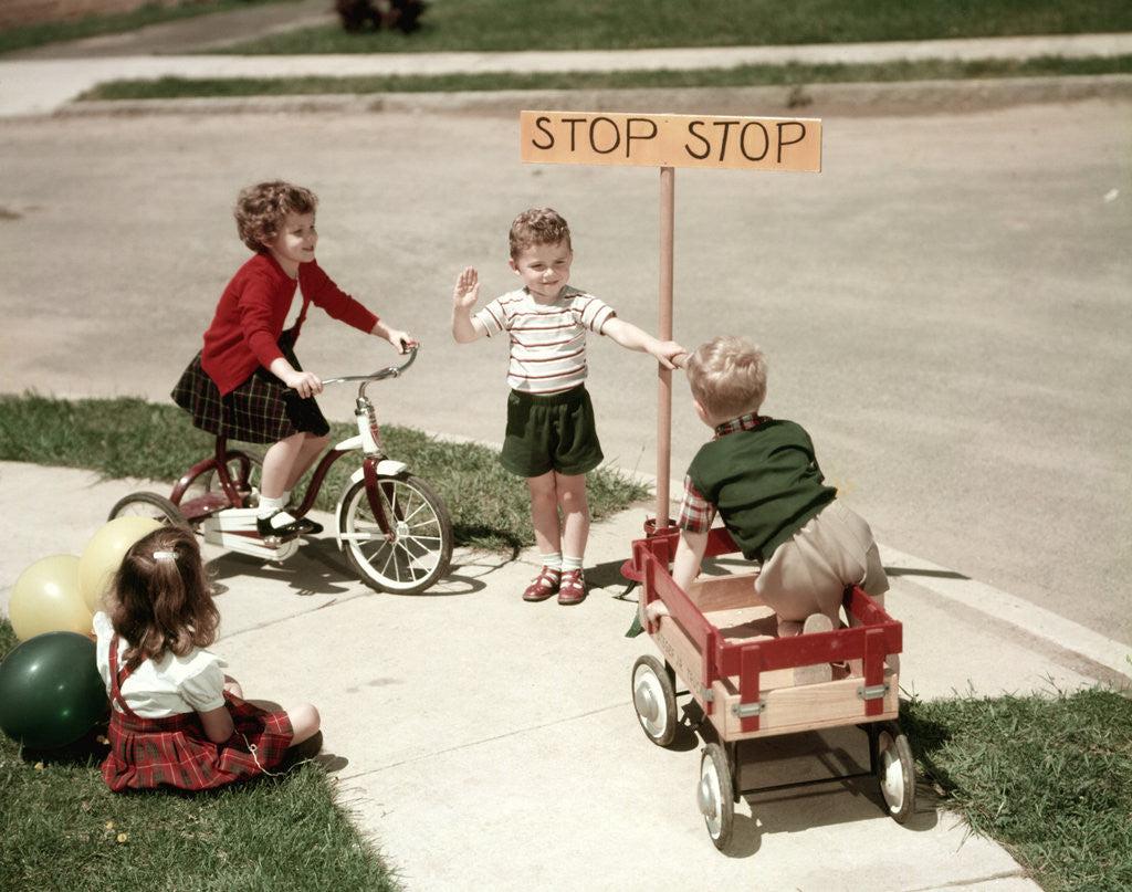 Detail of 1950s Boys And Girls Outdoor With Tricycle And Wagon Playing Traffic With Police Stop Sign Americana by Anonymous