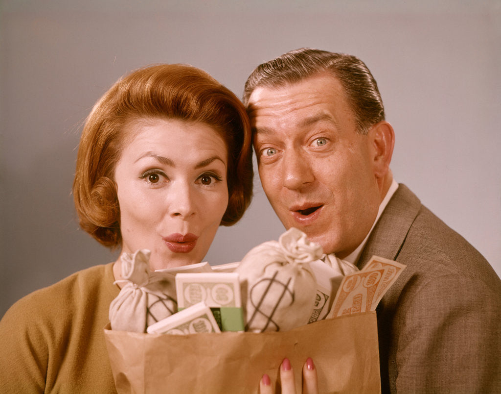 Detail of 1960s Surprised Happy Couple Man Woman With Grocery Bag Filled With Money by Anonymous