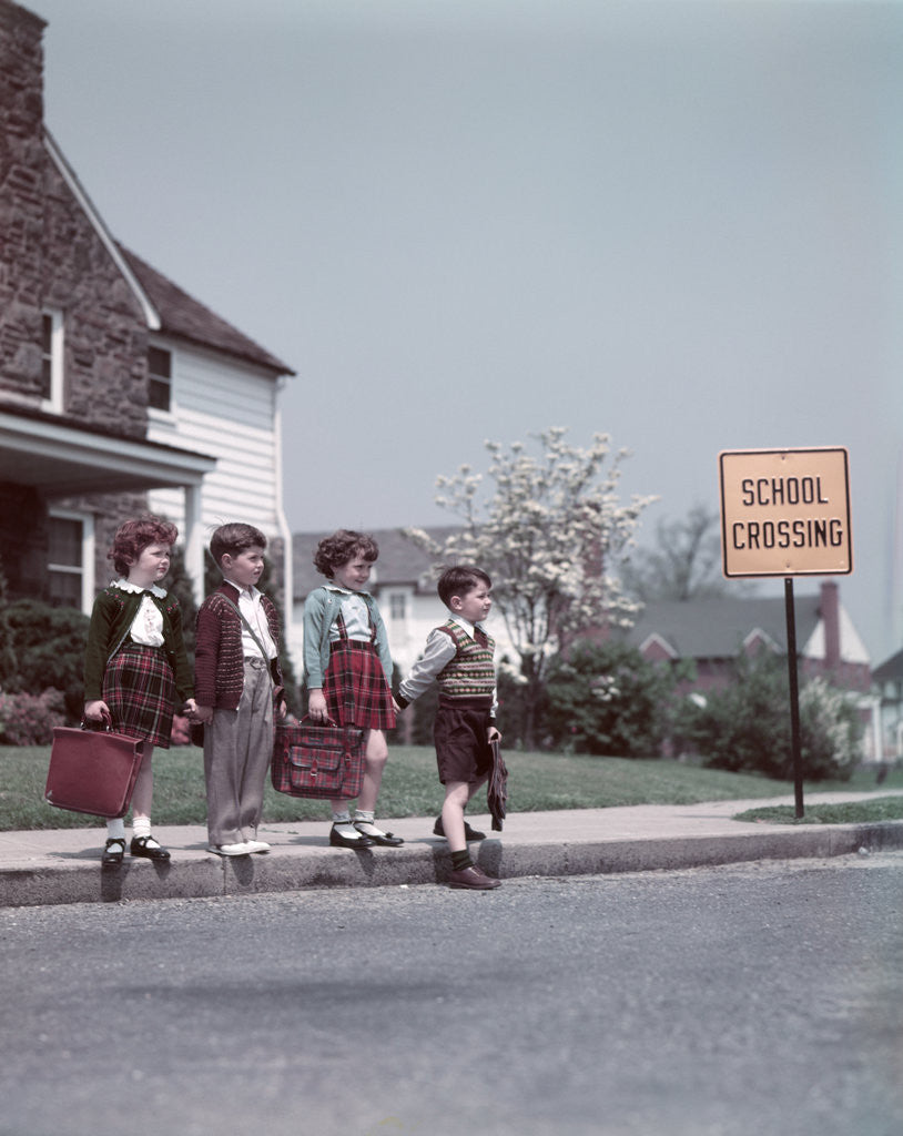 Detail of 1950s Kids On Suburban Neighborhood Sidewalk About To Cross Street By School Crossing Sign by Corbis
