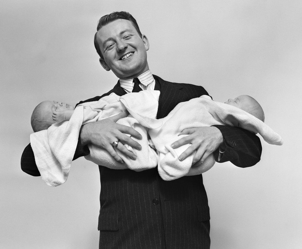 Detail of 1930s Proud Father Proudly Holding Twin Babies by Corbis