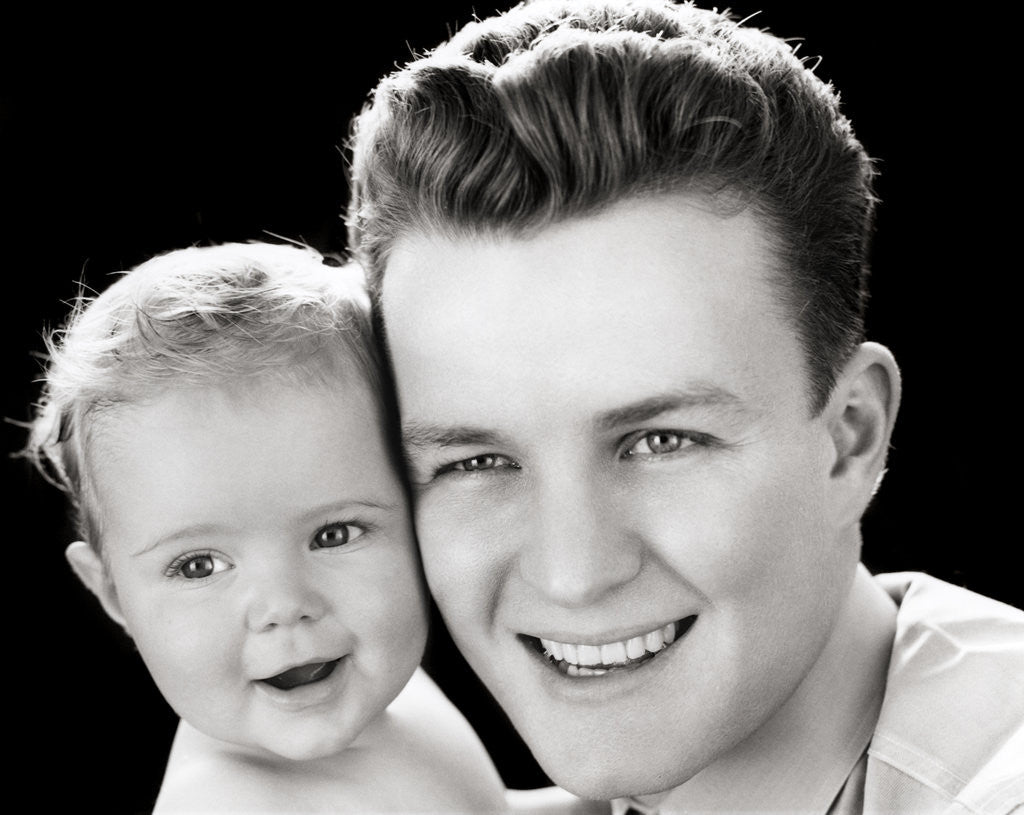 Detail of 1940s Portrait Of Father Holding Baby Daughter To Cheek by Corbis