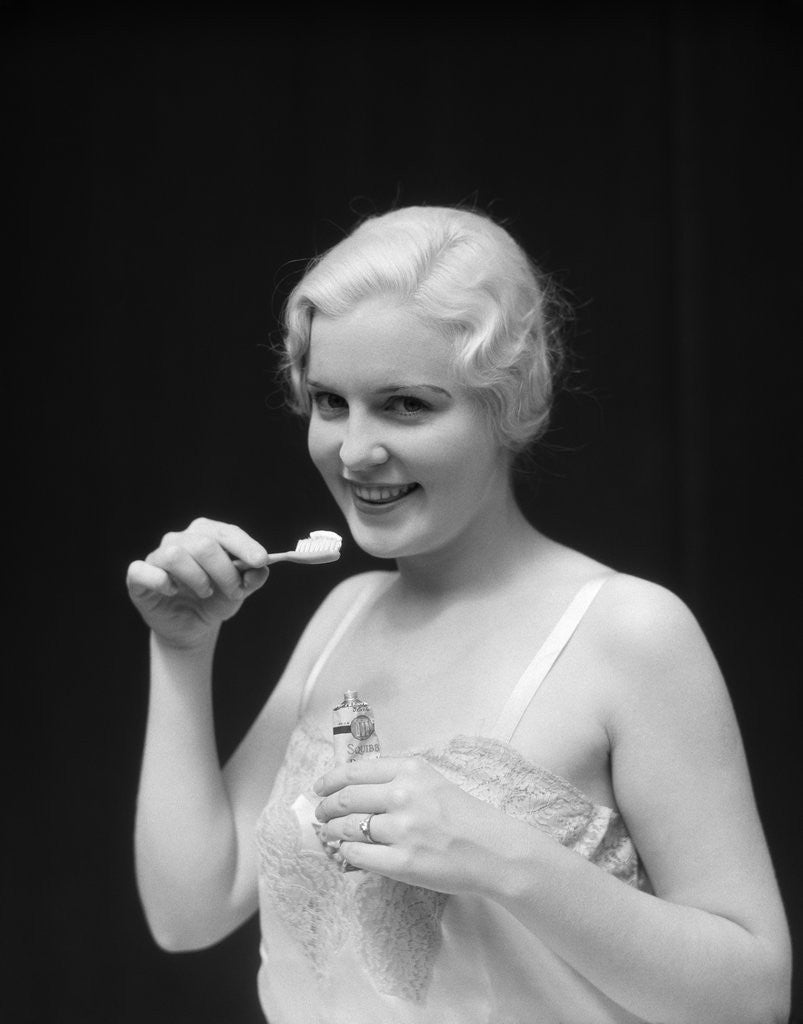 Detail of 1930s Woman Holding Tooth Paste And Tooth Brush Btushing Teeeth by Corbis