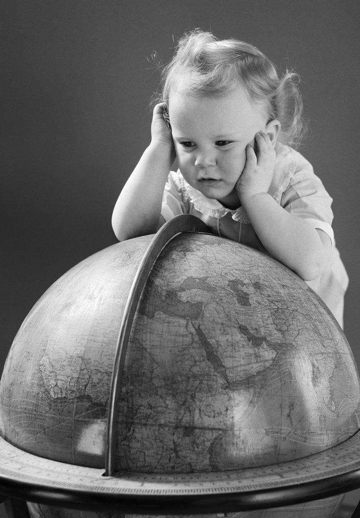 Detail of 1940s Baby Looking At Leaning On Globe Of Earth by Corbis