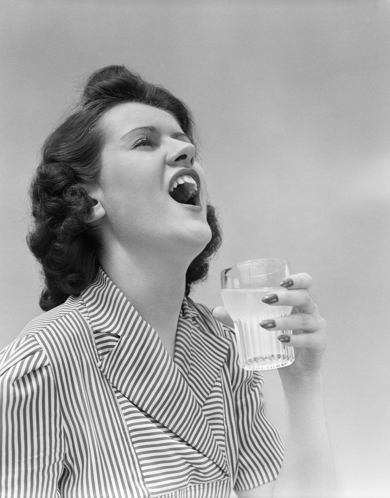 1940s Woman Gargling Medicine Holding A Glass Indoor by Corbis