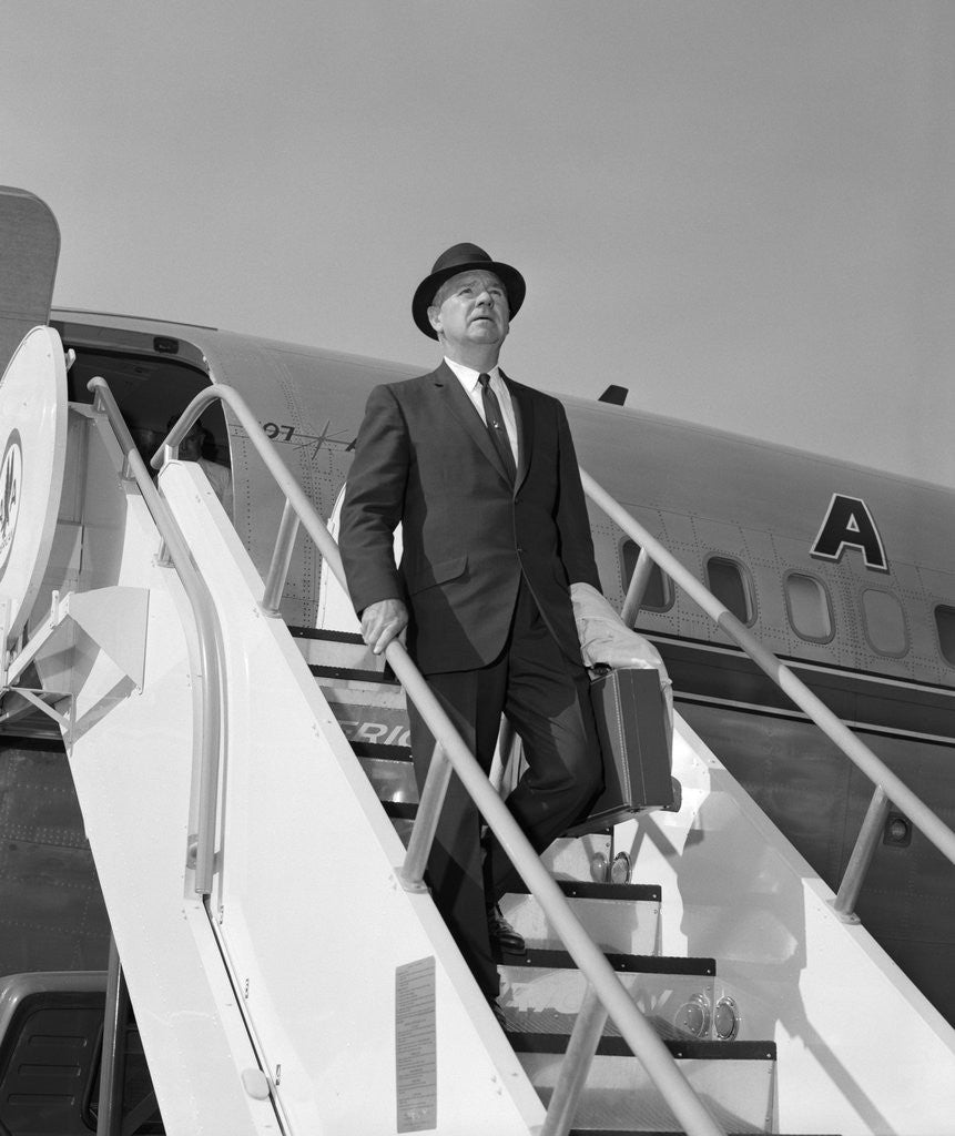 Detail of 1960s Businessman Deplaning From Airplane Wearing Hat And Carrying Overcoat And Briefcase by Anonymous